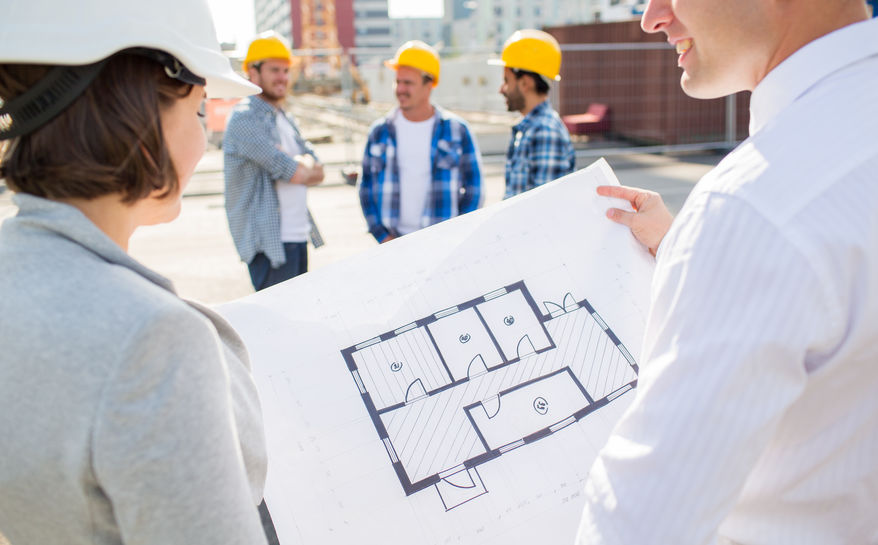 close up of architects with blueprint at building